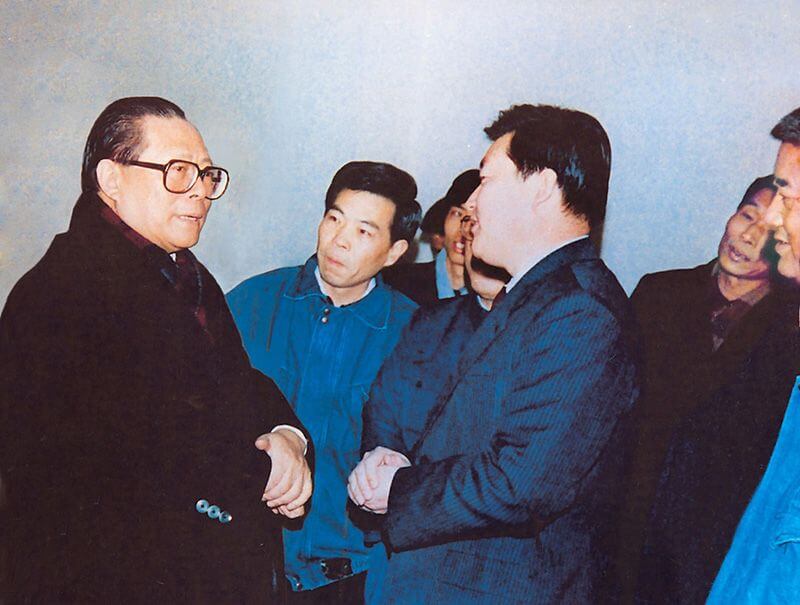 1991年2月5日，时任中共中央总书记的江 泽 民（左一）视察利来国际，他指示：“抓住机遇，深化改革，扩大开放，促进发展，保持稳定。”